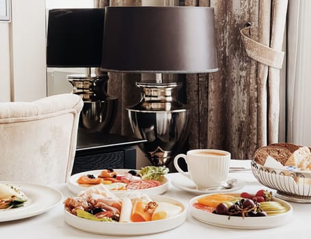 Luxury hotel and five star room service, various food platters, bread and coffee as in-room breakfast for travel and hospitality brand