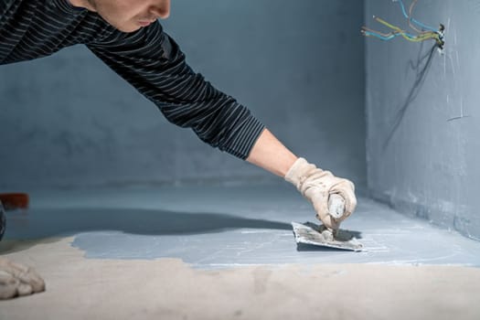 bricklayer works with trowel in room. High quality photo