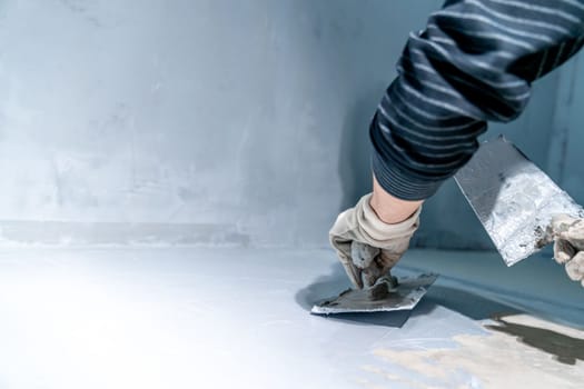 work with trowel on floor and wall in new room in building. High quality photo