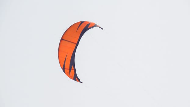 orange sport kite in the sky, parachute.