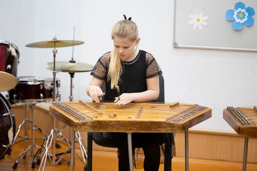 May 21, 2021 Belarus. city of Gomil. Holiday at the music school.The girl plays the ethnic instrument dulcimer