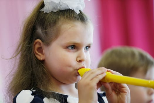 Belarus, Gomil city, May 16, 2019 Matinee in kindergarten.A little girl blows a musical pipe.
