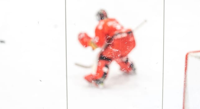 blurred view through protective safety glass. hockey goalie on the ice of the winter stadium. High quality photo