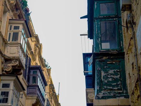 Fragment of the building's facade with traditional wooden ornate balconies painted in Valletta, Malta. High quality photo