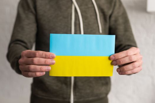 Ukrainian flag in hands. The concept of ending the war in Ukraine