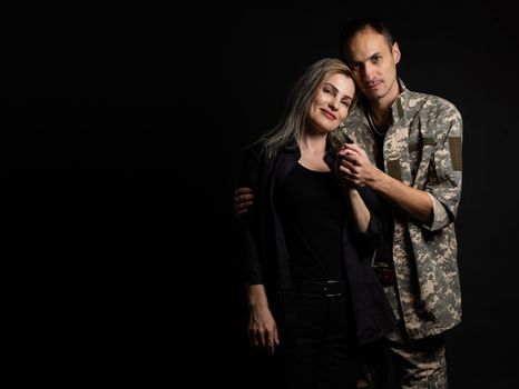 military man and his wife on a black background.