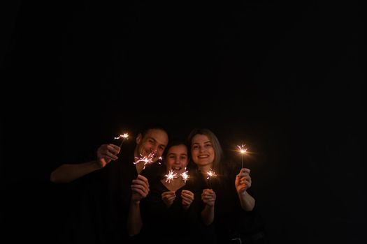 family with sparklers on a black background.