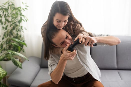 family, gaming and entertainment concept - happy father and little daughter with gamepads playing video game at home.