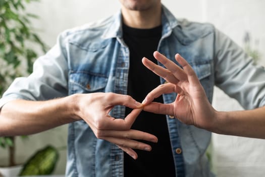 Sign language interpreter man translating a meeting to ASL, American Sign Language. Empty copy space for Editor's content.