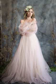 A young blonde in an airy tulle pink dress. Spring portrait of a woman