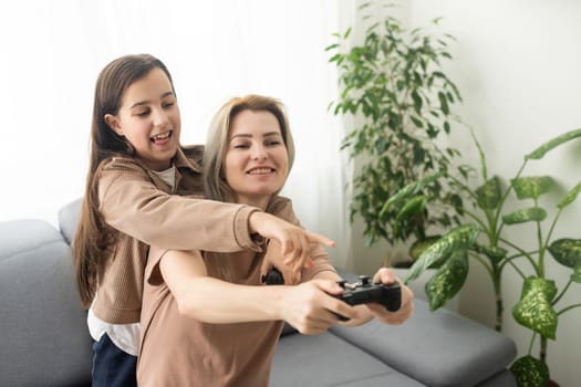happy family together. mother and her child girl playing video games. family relax