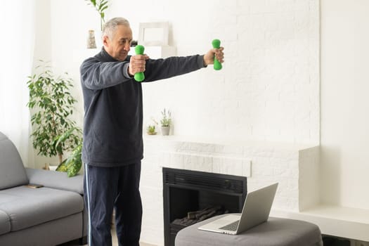 Online workout. elderly man doing exercise with online tutorial at home, panorama, free space.