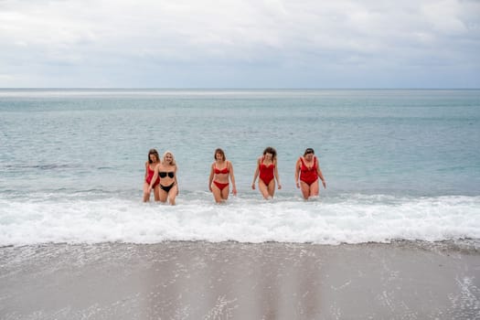 Big happy family or group of five friends is having fun against sunset beach. Beach holidays concept