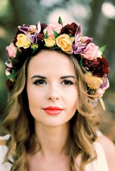 Bride in a bright wreath of roses and orchids. Portrait. High quality photo