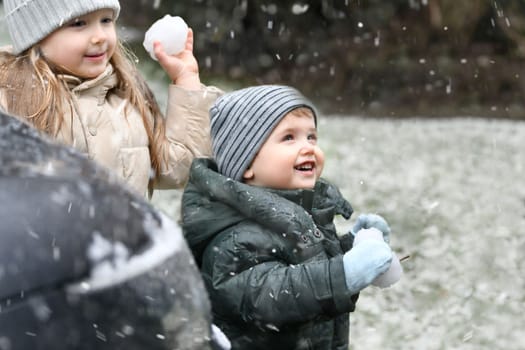 The kids playing snowballs outside