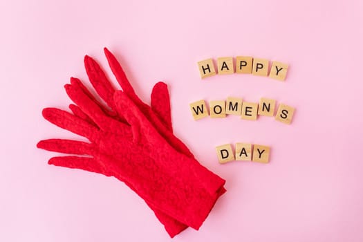 Beautiful red lace gloves on which wooden cubes with the inscription happy women's day. Ready card for the holiday, Women's Day