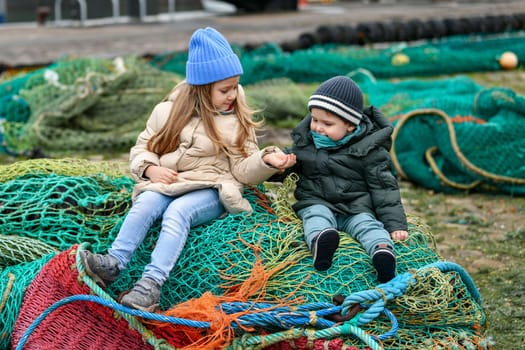 Brother and sister playing at the fishing nets