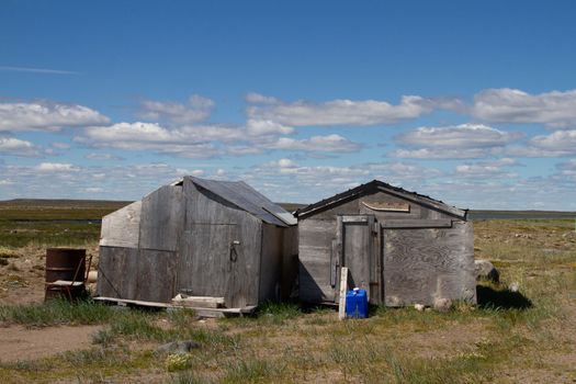 Abandoned buildings on a bare arctic summer landscape. Near Arviat, Nunavut, Canada