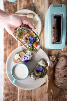 delicious bruschetta with homemade bread, garnished with fig,soft cheese,pansies, top view. High quality photo