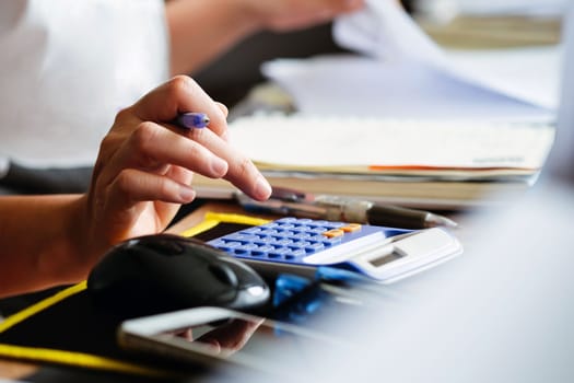 Close up female hands of accountant with calculator and pen. business accounting background.