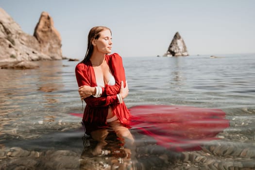 Woman travel sea. Happy tourist taking picture outdoors for memories. Woman traveler looks at the edge of the cliff on the sea bay of mountains, sharing travel adventure journey.