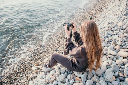 Woman travel sea. Happy tourist taking picture outdoors for memories. Woman traveler looks at the edge of the cliff on the sea bay of mountains, sharing travel adventure journey.