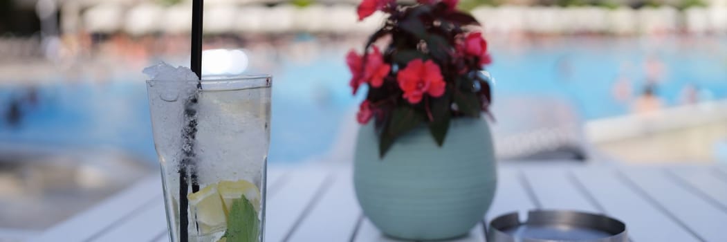 Lemonade and soft drinks in glass with ice. Summer cocktails drink on table by pool