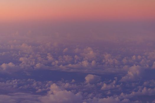 Pink glow on horizon over clouds and blue ocean at sunrise. High quality photo