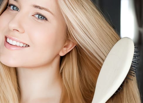 Beautiful happy woman combing her long blond hair.