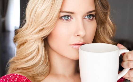 Beautiful blonde woman having a cup of tea in the morning at home.