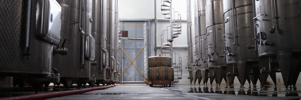 Modern winery interior with large metal tanks. Production and line of industrial chemical tanks in chemical pharmaceutical production