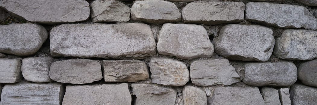 Stone old wall fencing seamless texture closeup. Background stones