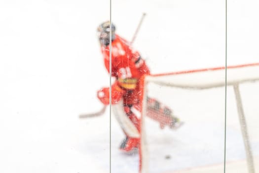 blurred view through protective safety glass. hockey goalie on the ice of the winter stadium. High quality photo