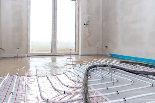 installation of concrete and anhydrite on underfloor heating in a room of a newly built family house. High quality photo