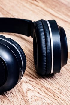 Black headphones on a wooden background close up