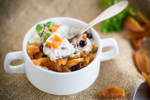 oatmeal with candied fruits, raisins in a plate on a burlap tablecloth