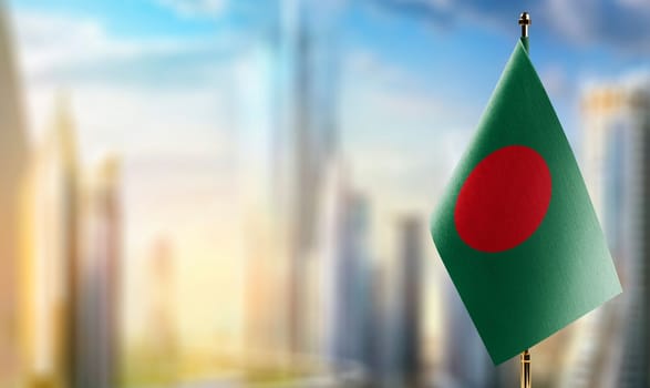 Small flags of the Bangladesh on an abstract blurry background.