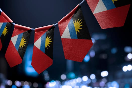 A garland of Antigua and Barbuda national flags on an abstract blurred background.