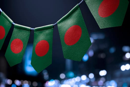 A garland of Bangladesh national flags on an abstract blurred background.