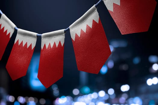 A garland of Bahrain national flags on an abstract blurred background.