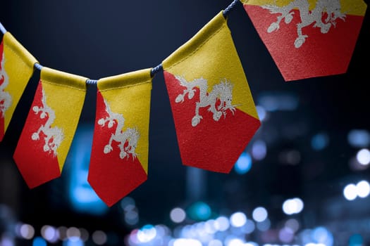 A garland of Bhutan national flags on an abstract blurred background.