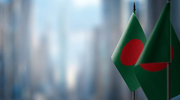 Small flags of the Bangladesh on an abstract blurry background.