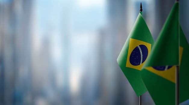 Small flags of the Brazil on an abstract blurry background.