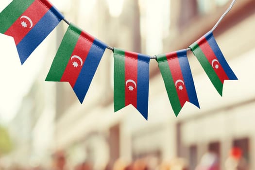 A garland of Azerbaijan national flags on an abstract blurred background.