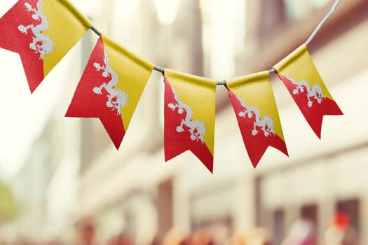 A garland of Bhutan national flags on an abstract blurred background.