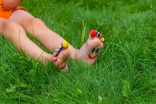 a smile painted with paints on the child's arms and legs. Selective focus
