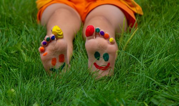 a smile painted with paints on the child's arms and legs. Selective focus