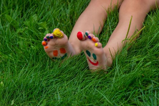 a smile painted with paints on the child's arms and legs. Selective focus