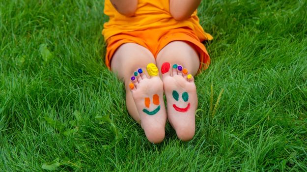 a smile painted with paints on the child's arms and legs. Selective focus