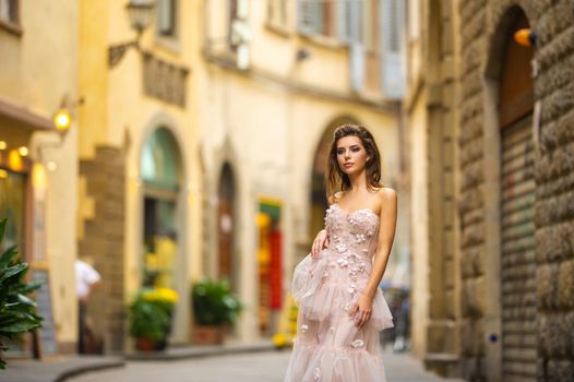 A bride in a pink wedding dress walks in Florence, Italy.